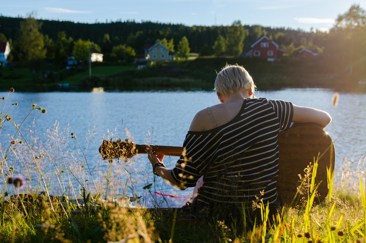 Woman playing the guitar at the lake